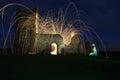 An old derelict church at night with sparks and light trails exploding from it