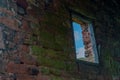 An old derelict, rotted green window frame against a red brick wall and a blue sky. Royalty Free Stock Photo