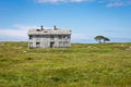 Old deserted wooden farmhouse on a green field. Lonely house in a picturesque landscape. Old abandoned farm house Royalty Free Stock Photo