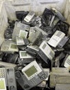 Old desk telephones in a heap at a recycling centre for metals recovery