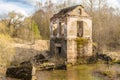 The old destroyed building of the hydroelectric plant with moss-grown walls is located in a forest surrounded by dry grass Royalty Free Stock Photo