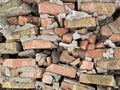 Old destroyed red brick wall on the ground. The wreckage of a dumped brick house. Background texture: pieces of stone wall