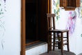 Old detached house entrance and old wooden chair in front of the painted wall Royalty Free Stock Photo