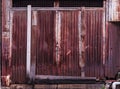 Old detailed aged vintage rusty corrugated red brown textured zinc alloy metal sheet exterior fence used in construction industry Royalty Free Stock Photo