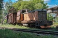 Old diesel locomotive with broken wooden cargo wagon on railway