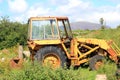 An old digger rusting in the weeds. Royalty Free Stock Photo