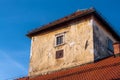 Old dilapidated house tower with fading and flaking facade Royalty Free Stock Photo
