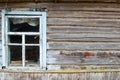 Old dilapidated window of a wooden village house and a wall of dilapidated log Royalty Free Stock Photo