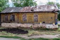 An old dilapidated wooden house with closed shutters and a leaky roof Royalty Free Stock Photo