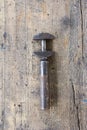 Old, dirty adjustable wrench against wooden plank. Royalty Free Stock Photo