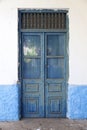 Old dirty blue wooden door in wall of stone house on peloponnese Royalty Free Stock Photo