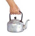 Old dirty classic aluminum kettle holding in hand isolated on wh