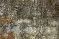 A old dirty concrete wall with protruding red bricks. uneven rough surface. stains of cement and paint Royalty Free Stock Photo