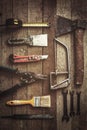 Old and dirty construction tools on wooden background