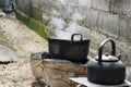 Old dirty cooking pot and bowl boiled water with steam.