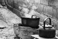 Old dirty cooking pot and bowl boiled water with steam.