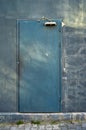 Old dirty iron door and door closer on gray cracked wall Royalty Free Stock Photo