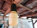 Old Dirty LED Light Bulb Hanging from a Rustic Wooden Ceiling Royalty Free Stock Photo
