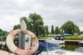 Old and dirty life ring seen hocked over a boating power outlet, seen in an inland harbour. Royalty Free Stock Photo