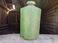 old and dirty pale green plastic bottle on wooden background