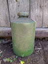 old and dirty pale green plastic bottle on wooden background