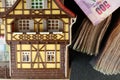 Old and dirty plastic house model put beside banknote. Royalty Free Stock Photo