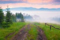 Old dirty road in foggy Carpathian mountains. Royalty Free Stock Photo