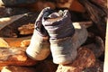 Old dirty rubber boots on a pile of firewood, rural lifestyle concept Royalty Free Stock Photo