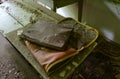 Old dirty school bag and folder for papers on desk in abandoned elementary school in village of Dronki in exclusion zone of