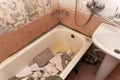 an old dirty shabby bathroom with fallen tiles. an old ruined bathroom