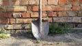 old dirty shovel on brick wall background. garden tools Royalty Free Stock Photo