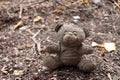 Old dirty teddy bear neglected on the ground soil. Royalty Free Stock Photo