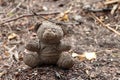 Old dirty teddy bear neglected on the ground soil. Royalty Free Stock Photo