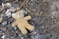 Old dirty teddy bear neglected on the ground soil. End of childhood Royalty Free Stock Photo