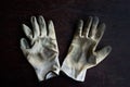 old dirty textile work gloves on dark wooden background