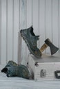 Old dirty torn work boots,worn to holes,timber board,steel tool box,axe with wooden handle.Durable shoe concept.Vertical Royalty Free Stock Photo