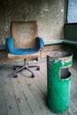 An old dirty vintage armchair covered with a blue rag and a green rusty urn Royalty Free Stock Photo