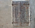 Old dirty wall with closed window with shutters. Aged italian street wall background with bricks and plaster