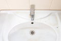 Old dirty washbasin with rust stains, limescale and soap stains in the bathroom with a faucet, water tap