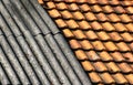 Old dirty weathered wavy slate and ceramic tiles shingle roof