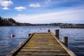 Old dirty wooden pier or jetty for yachts and boats. Spring landscape of the coast of Sweden. Royalty Free Stock Photo