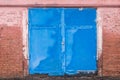 Old dirty worn weathered iron warehouse blue door with brick wall of building abandoned architecture Royalty Free Stock Photo