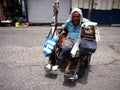 An old disabled man rolls around in his wheelchair in a public market.