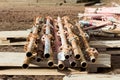 Old disassembled scaffolding in the form of tubes, painted in paint lie on the construction site for the restoration of the palace