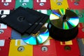 Old diskette 5 25 inches with 3.5 floppy disks of various colors with modern DVD.