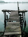 Old dock floating in foggy weather with town showing up in the background