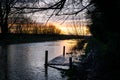 Old dock flooded by flood while lit by beautiful sunset.