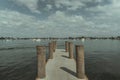 Old dock with wooden bollards over a calm coast on a cloudy day