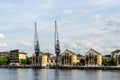 Old Dockside Cranes alongside a Waterfront Development  in London Royalty Free Stock Photo