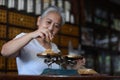 The old doctor of traditional medicine weight scales dry lotus pollen china herbs in chinese medicine shop. Royalty Free Stock Photo